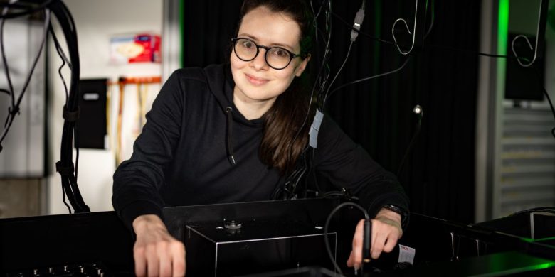 Lyuba Amitonova stands in a lab next to an optical experiment setup. Photo: Ivar Pel