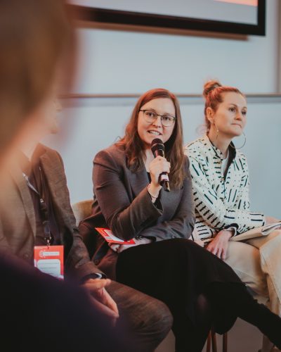 Emilia Olsson speaks into a microphone during the panel discussion.